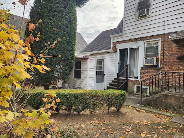 27 Allen St, Hempstead, NY 11550 - view of exterior entry with a shingled roof and cooling unit