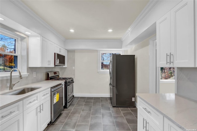 kitchen with a wealth of natural light, white cabinetry, sink, and appliances with stainless steel finishes