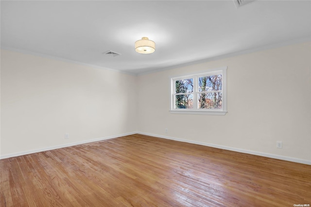 unfurnished room with hardwood / wood-style floors and ornamental molding