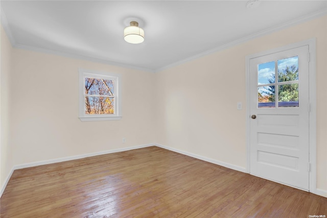 spare room with light hardwood / wood-style flooring and crown molding