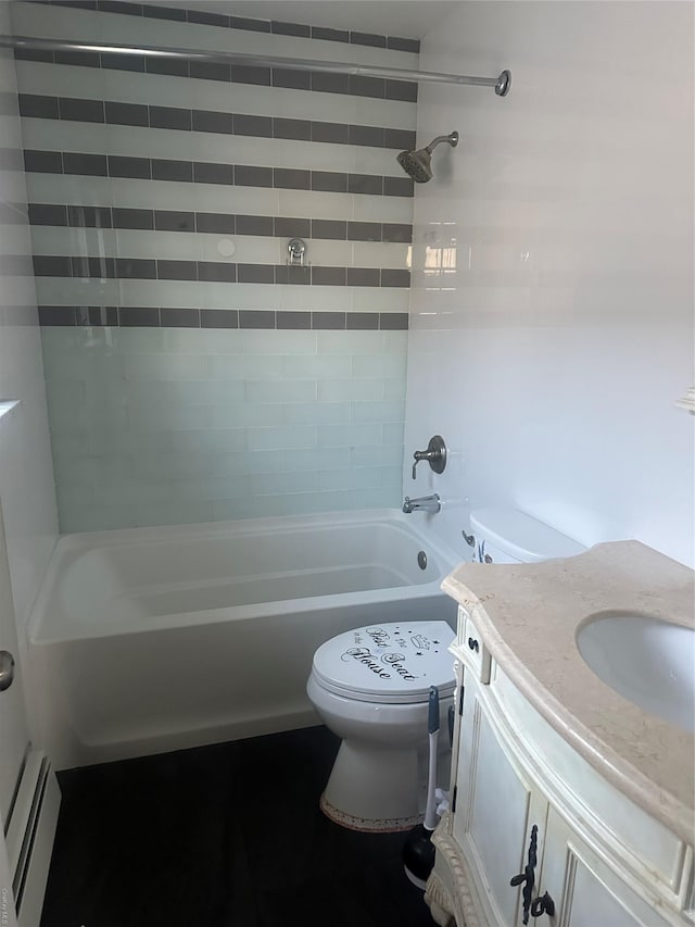 full bathroom featuring vanity, a baseboard heating unit, toilet, and tiled shower / bath