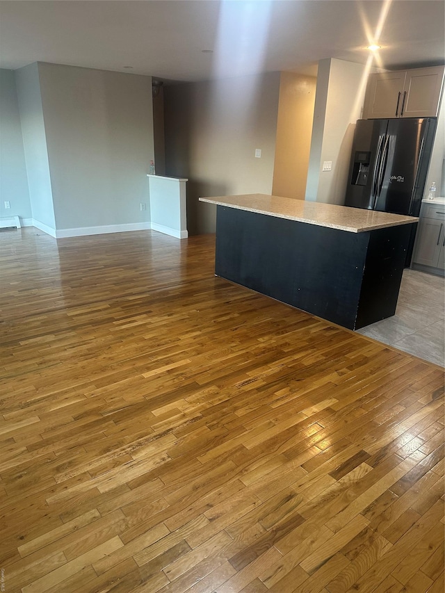 kitchen featuring light hardwood / wood-style floors, a kitchen island, and stainless steel fridge