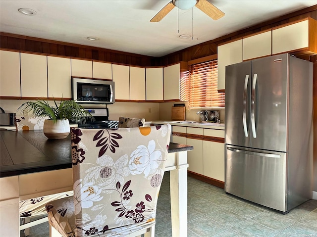 kitchen with cream cabinets, sink, and appliances with stainless steel finishes