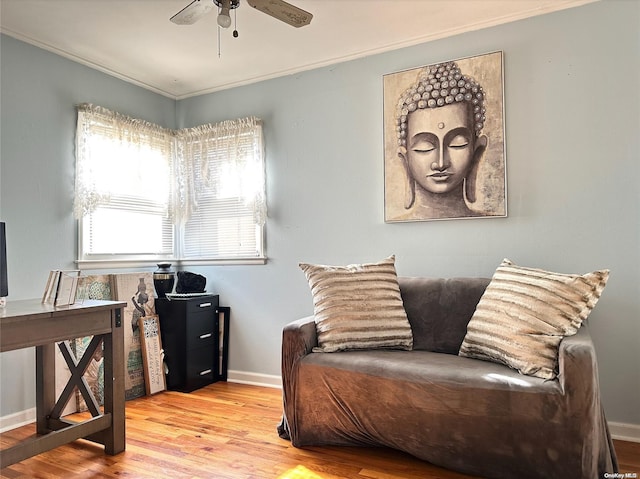 sitting room with ceiling fan, light hardwood / wood-style floors, and ornamental molding