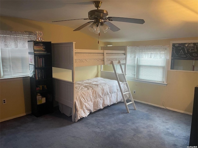 unfurnished bedroom with ceiling fan and dark colored carpet