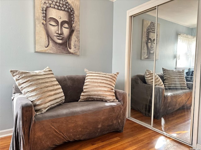 living area with hardwood / wood-style flooring and crown molding