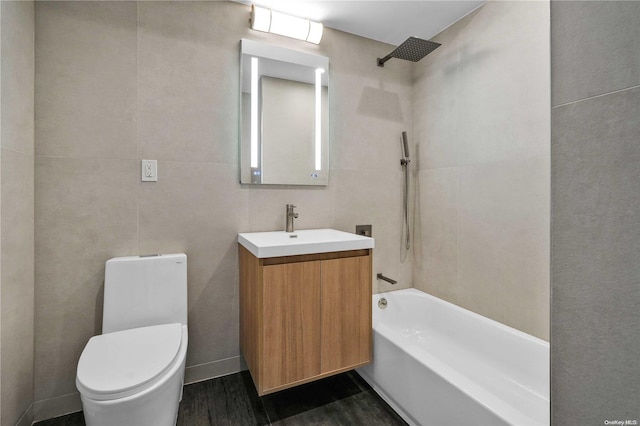 full bathroom with tub / shower combination, vanity, tile walls, hardwood / wood-style floors, and toilet