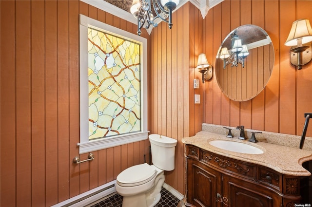 bathroom with tile patterned floors, vanity, crown molding, toilet, and wood walls