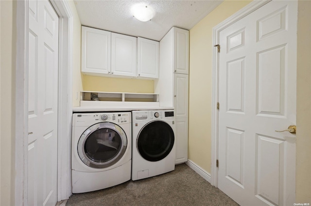 laundry area with cabinets, a textured ceiling, carpet flooring, and washing machine and clothes dryer