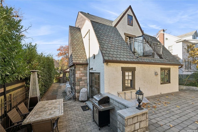 rear view of property featuring a patio and a balcony