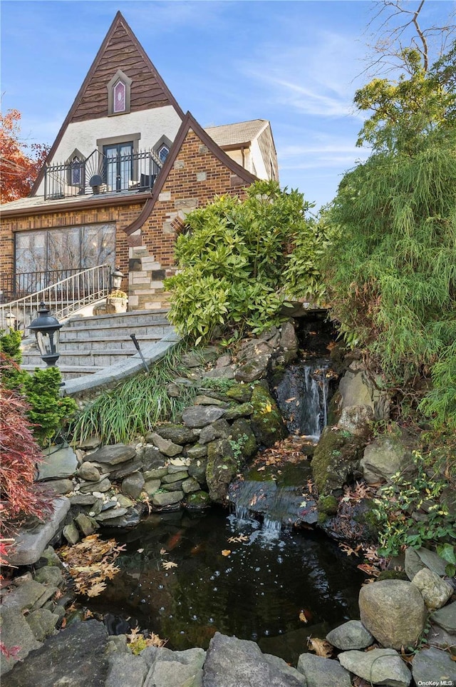 view of yard with a small pond and a balcony