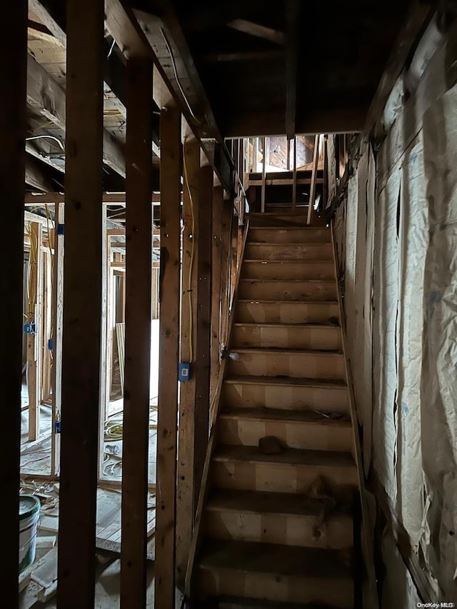 staircase with rustic walls