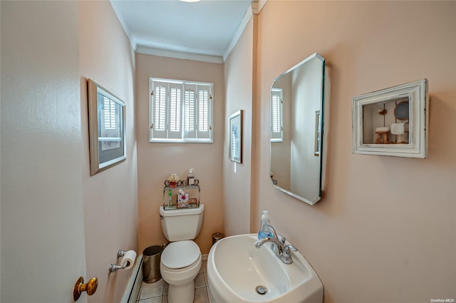 bathroom with toilet, tile patterned floors, crown molding, and sink