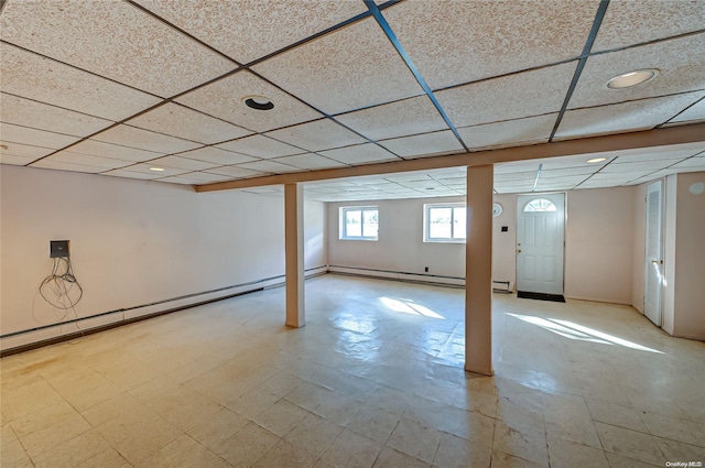 basement with baseboard heating and a drop ceiling