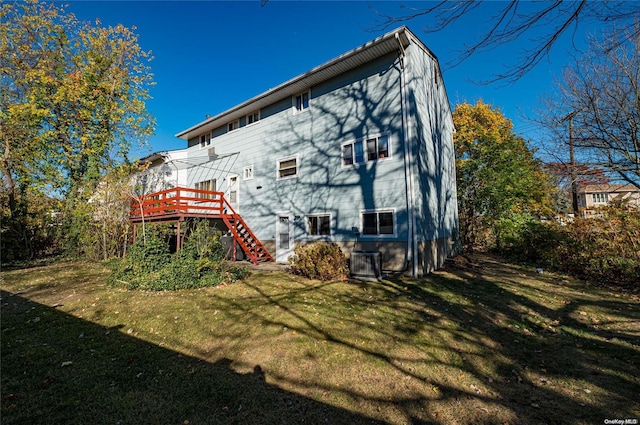 back of house featuring central AC, a lawn, and a wooden deck