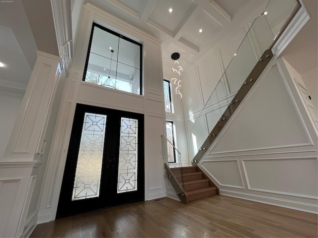 foyer with french doors, coffered ceiling, dark hardwood / wood-style flooring, beamed ceiling, and crown molding