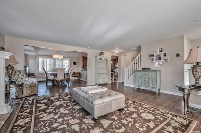 living room with an inviting chandelier, dark hardwood / wood-style flooring, and a baseboard heating unit