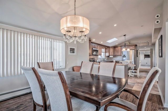 dining area featuring hardwood / wood-style flooring, a notable chandelier, baseboard heating, and vaulted ceiling