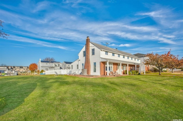 1 Jetmore Pl, Massapequa, NY 11758 - back of house featuring a chimney, covered porch, a yard, and brick siding