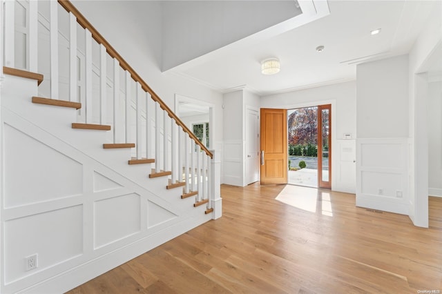 entrance foyer featuring light hardwood / wood-style floors and crown molding