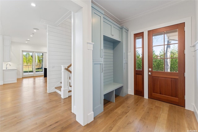 mudroom with light wood-type flooring, plenty of natural light, and crown molding