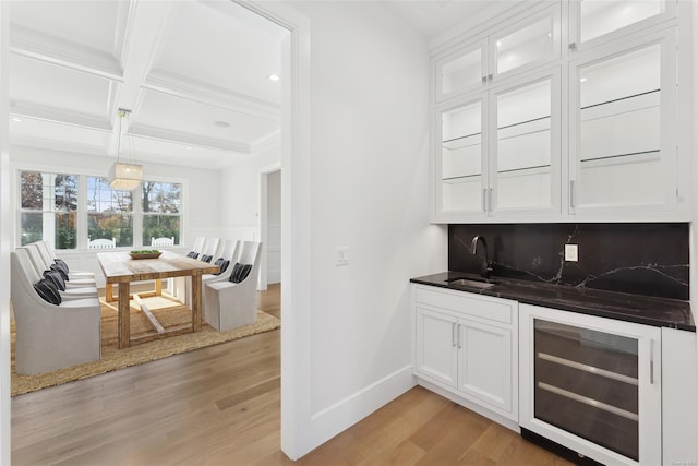 bar featuring white cabinets, decorative backsplash, wine cooler, and light hardwood / wood-style flooring