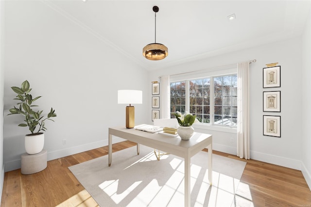 office space with vaulted ceiling, crown molding, and light hardwood / wood-style flooring