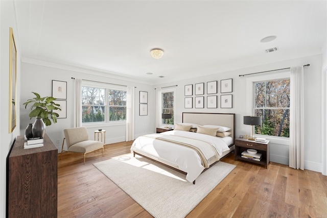 bedroom featuring light wood-type flooring and ornamental molding