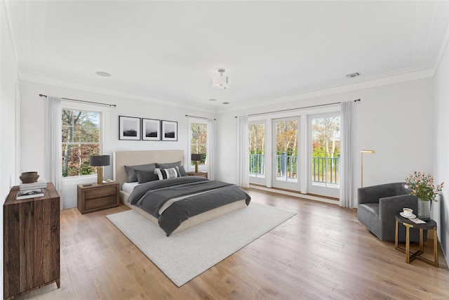 bedroom featuring access to exterior, light hardwood / wood-style floors, and ornamental molding