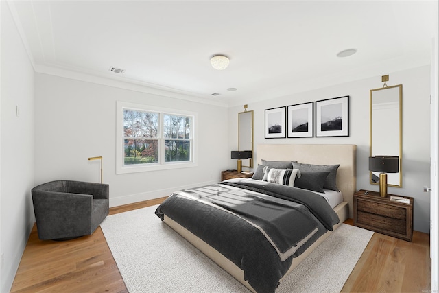 bedroom with light wood-type flooring and ornamental molding