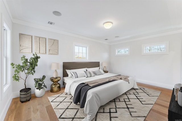 bedroom with light hardwood / wood-style flooring and ornamental molding