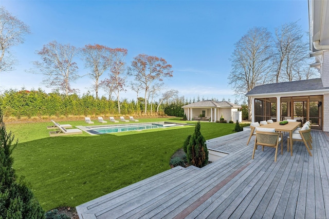 wooden terrace featuring a lawn, a sunroom, and a fenced in pool