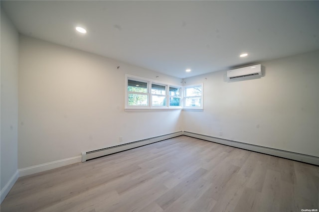 unfurnished room with light hardwood / wood-style flooring, an AC wall unit, and baseboard heating