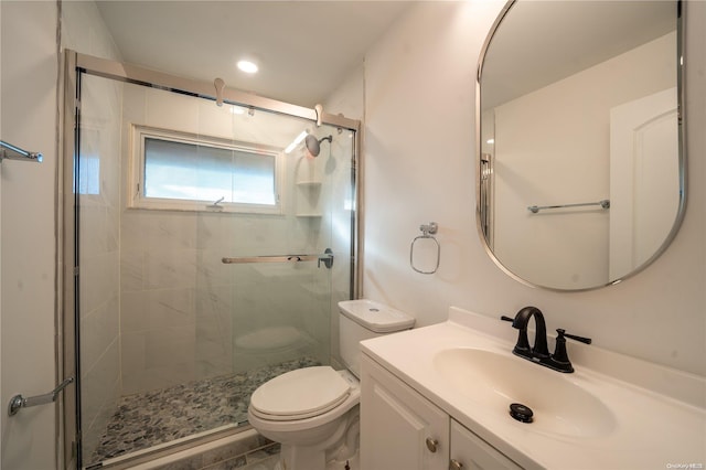 bathroom featuring vanity, toilet, and a shower with shower door