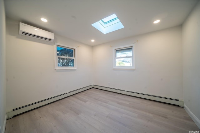 empty room with a skylight, a baseboard radiator, a wall mounted air conditioner, and light wood-type flooring