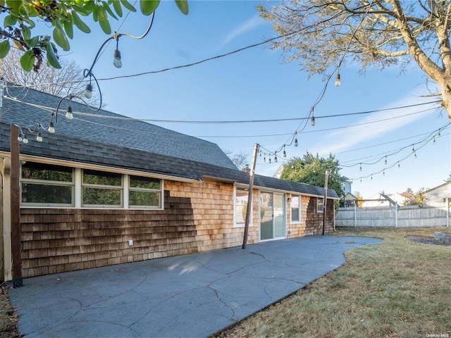 rear view of property featuring a lawn and a patio area