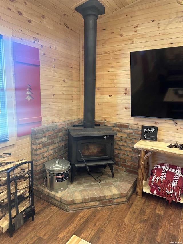 room details featuring a wood stove, wood walls, and hardwood / wood-style flooring