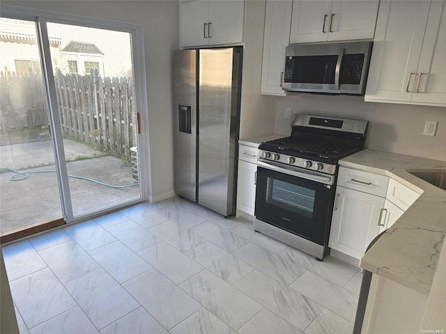 kitchen with light stone counters, white cabinets, and appliances with stainless steel finishes