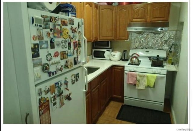 kitchen featuring tasteful backsplash and white appliances