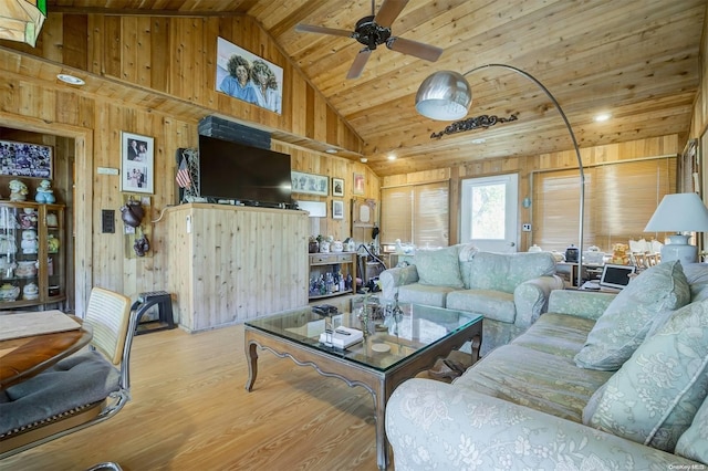 living room featuring high vaulted ceiling, light wood-type flooring, wooden walls, and wooden ceiling