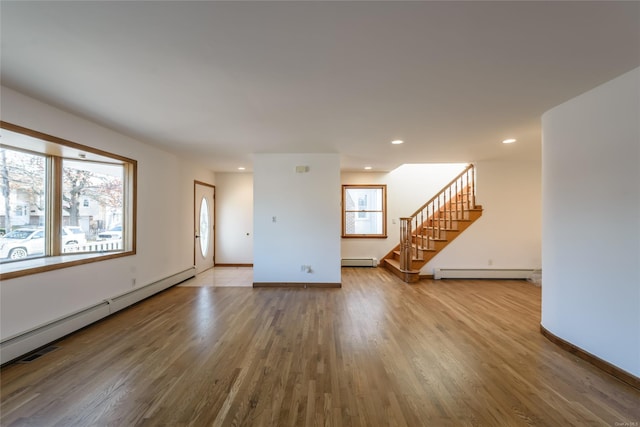 spare room featuring hardwood / wood-style flooring and baseboard heating