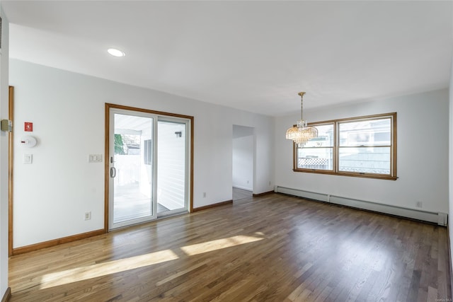 unfurnished room with hardwood / wood-style flooring, a notable chandelier, and a baseboard radiator