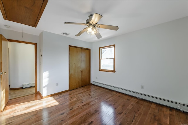 unfurnished bedroom featuring ceiling fan, a baseboard radiator, and light hardwood / wood-style floors