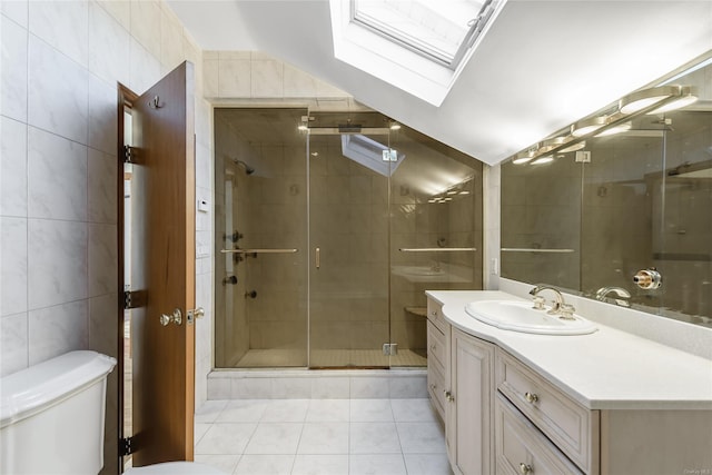 bathroom with lofted ceiling with skylight, tile patterned flooring, an enclosed shower, and tile walls