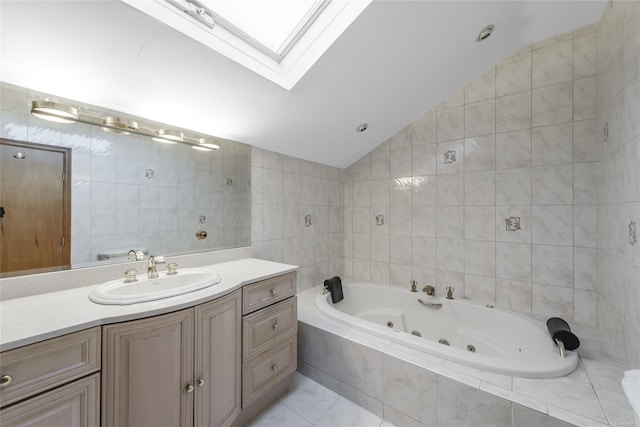 bathroom featuring vanity, a relaxing tiled tub, tile walls, and vaulted ceiling with skylight