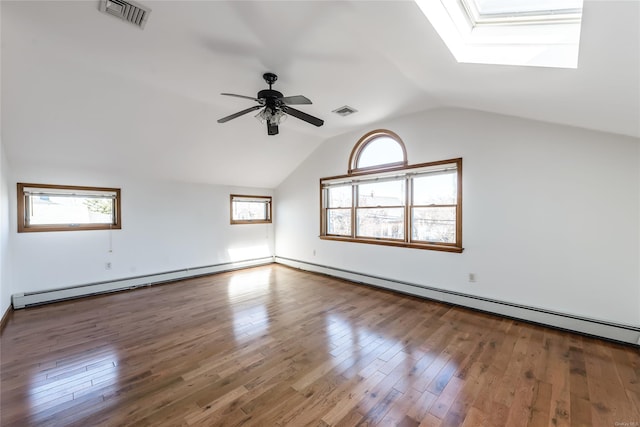 additional living space with a wealth of natural light, hardwood / wood-style floors, and vaulted ceiling with skylight