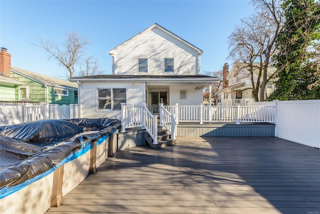 rear view of house with a pool side deck