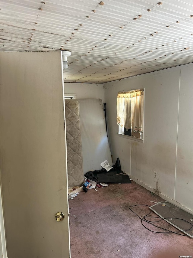 carpeted empty room featuring wood ceiling