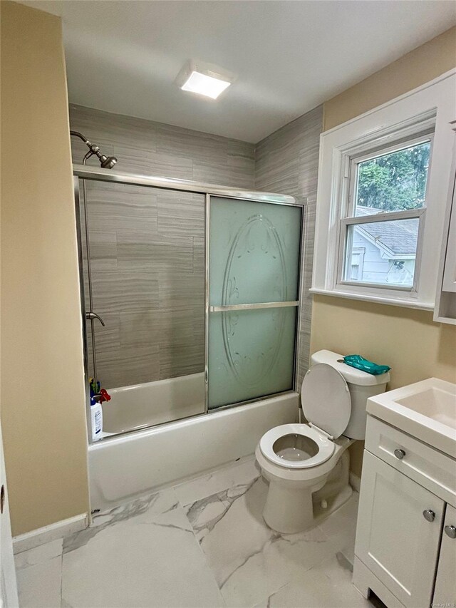 18 Perry St, Hempstead, NY 11550 - bathroom featuring toilet, marble look tiles, vanity, and bath / shower combo with glass door
