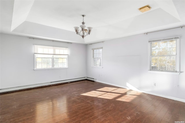 spare room with dark hardwood / wood-style flooring, a baseboard radiator, plenty of natural light, and a notable chandelier